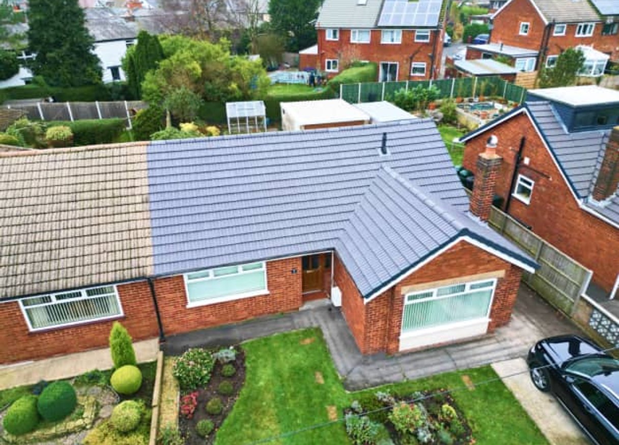 Aerial view of brick home with gray tile roof
